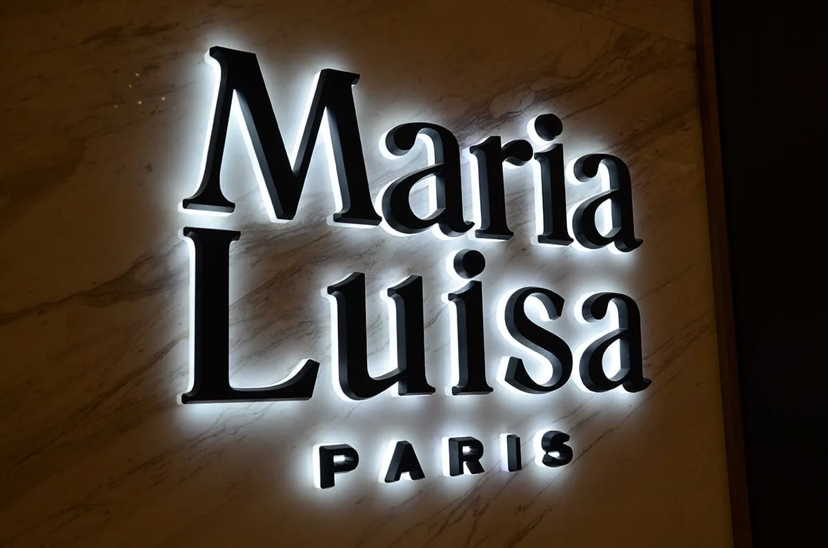 Backlit acrylic solid letters under a covered storefront entrance
